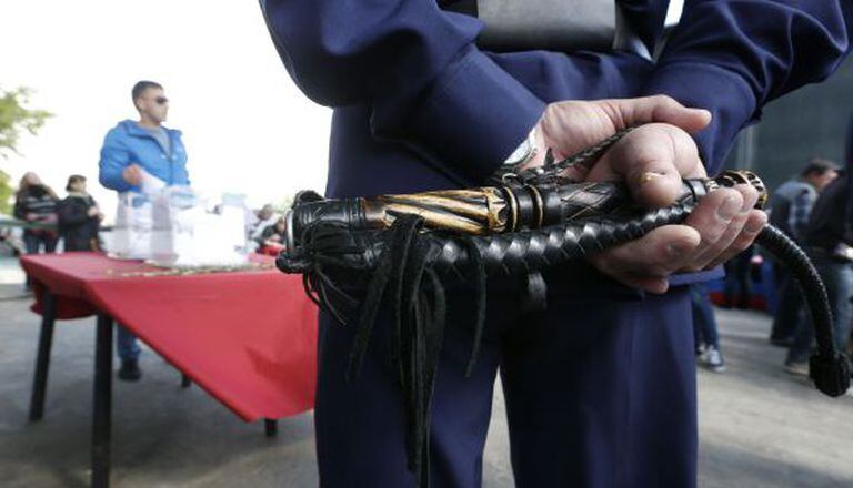 Um cossaco vigia uma urna com um chicote em mãos em uma sede eleitoral para o referendo ucraniano, em Moscou.
