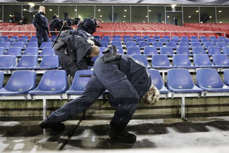 Policiais inspecionam as grades do estádio de Hanover.