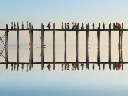 El puente de U Bein, realizado en madera de teca y con 1.000 postes, cruza el lago Taungthaman cerca de Amarapura (Myanmar).