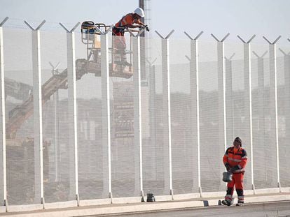 Operários franceses instalam arames farpados em uma cerca perto do porto de Calais, nesta quarta-feira.