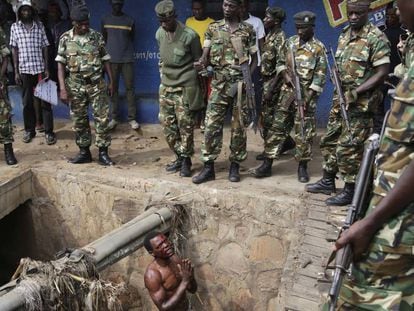 Suposto integrante da milícia juvenil Imbonerakure, do partido governante, suplica a soldados que o protejam de uma multidão de manifestantes em maio de 2015 no Burundi
