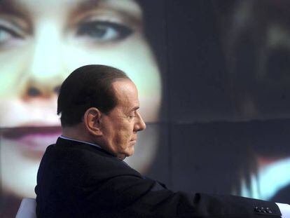Silvio Berlusconi no primeiro plano, com sua ex-mulher Veronica Lario ao fundo da imagem