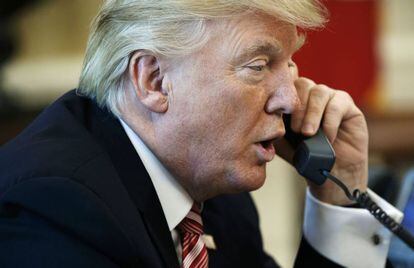 O presidente Donald Trump fala ao telefone em seu gabinete em janeiro de 2017.