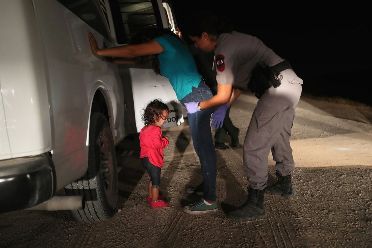 Menina hondurenha chora enquanto sua mãe é revistada pela patrulha fronteiriça em McAllen (Texas), em 2018.
