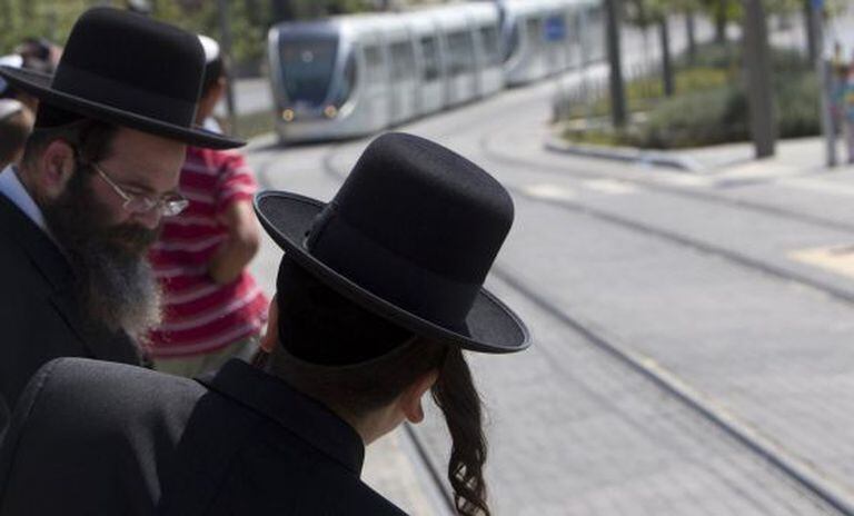 Pessoas esperam o bonde em Jerusalém.