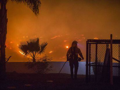 Um bombeiro tenta proteger uma casa em Lilac (Califórnia).