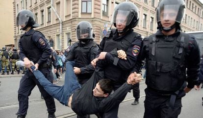 Um manifestante é preso por quatro policiais, neste domingo em San Petersburgo.
