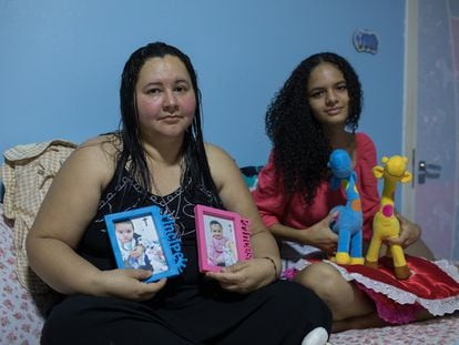 Mayra Pires Lima, de 38 anos, ao lado da sobrinha Evelyn, de 15 anos. Elas seguram as fotos, roupas e brinquedos do casal de bebês Gabriel e Sophia. As crianças ficaram órfãs após a morte da mãe por covid-19. Mayra ficou com a guarda de todos os sobrinhos.