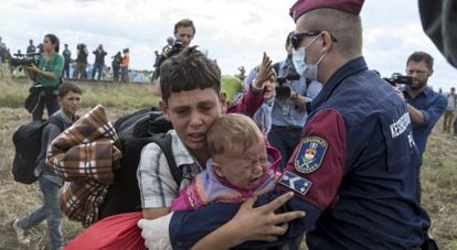 Policial húngaro barra a passagem de crianças refugiadas em Röszke (Hungria), em 8 de setembro de 2015.
