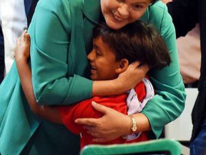 Dilma Rousseff abra&ccedil;a garoto em evento com trabalhadores rurais.