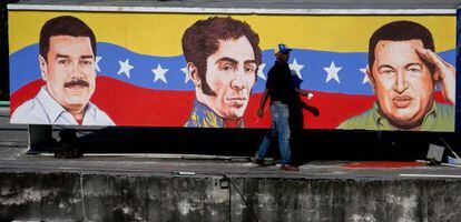 Um homem caminha diante de um mural na capital venezuelana.