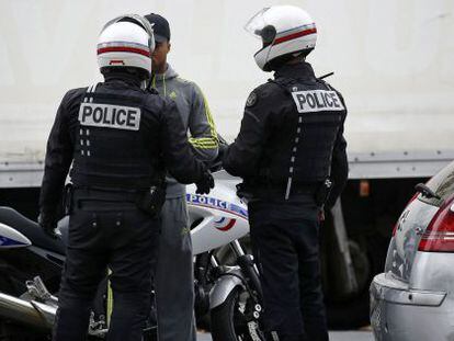 Policial francesa revista um homem no centro de Paris.