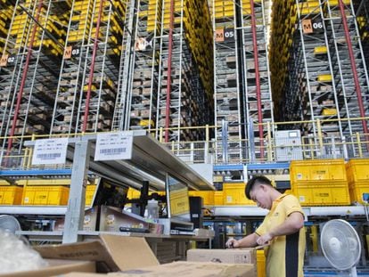 Funcionário da Suning na área onde os produtos são separados por unidades e guardados em estantes robotizadas de 24 metros de altura.
