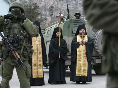 Sacerdotes ortodoxos rezam perto de soldados russos na Balaclava (Crimeia).