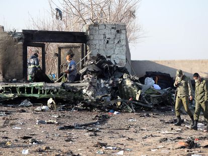 Soldados iranianos caminham pelos restos do avião ucraniano derrubado que deixou 176 pessoas mortas