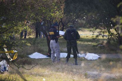 Policiais nas fossas em La Barca (Jalisco), ao lado do cemitério local.