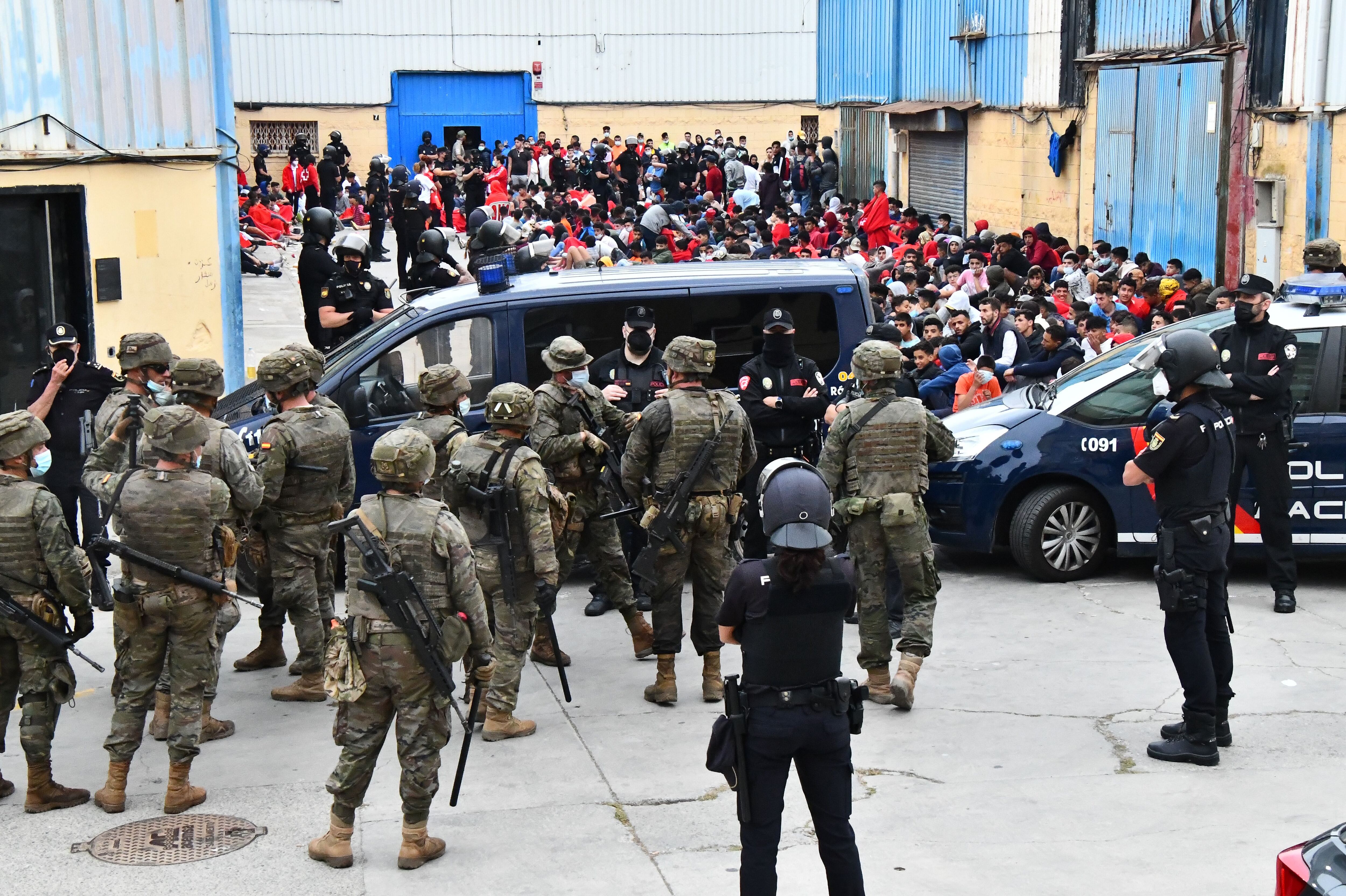 A Polícia Nacional e o Exército custodiam os imigrantes nos galpões de El Tarajal (Ceuta). 