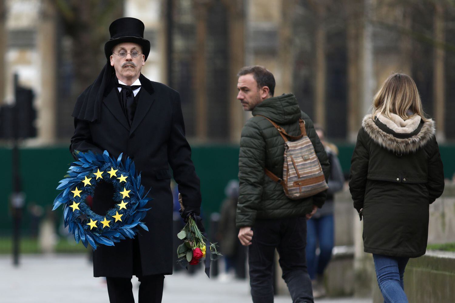 Homem carrega guirlanda em símbolo da União Europeia na praça do Parlamento, em Londres, nesta sexta-feira.