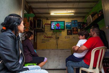 Um grupo de pessoas olha a final em uma favela de São Paulo.