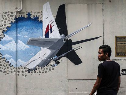 Um homem caminha ao lado de um mural em homenagem ao voo MH370 em Shah Alam, nos arredores de Kuala Lumpur (Malásia), em março de 2015.