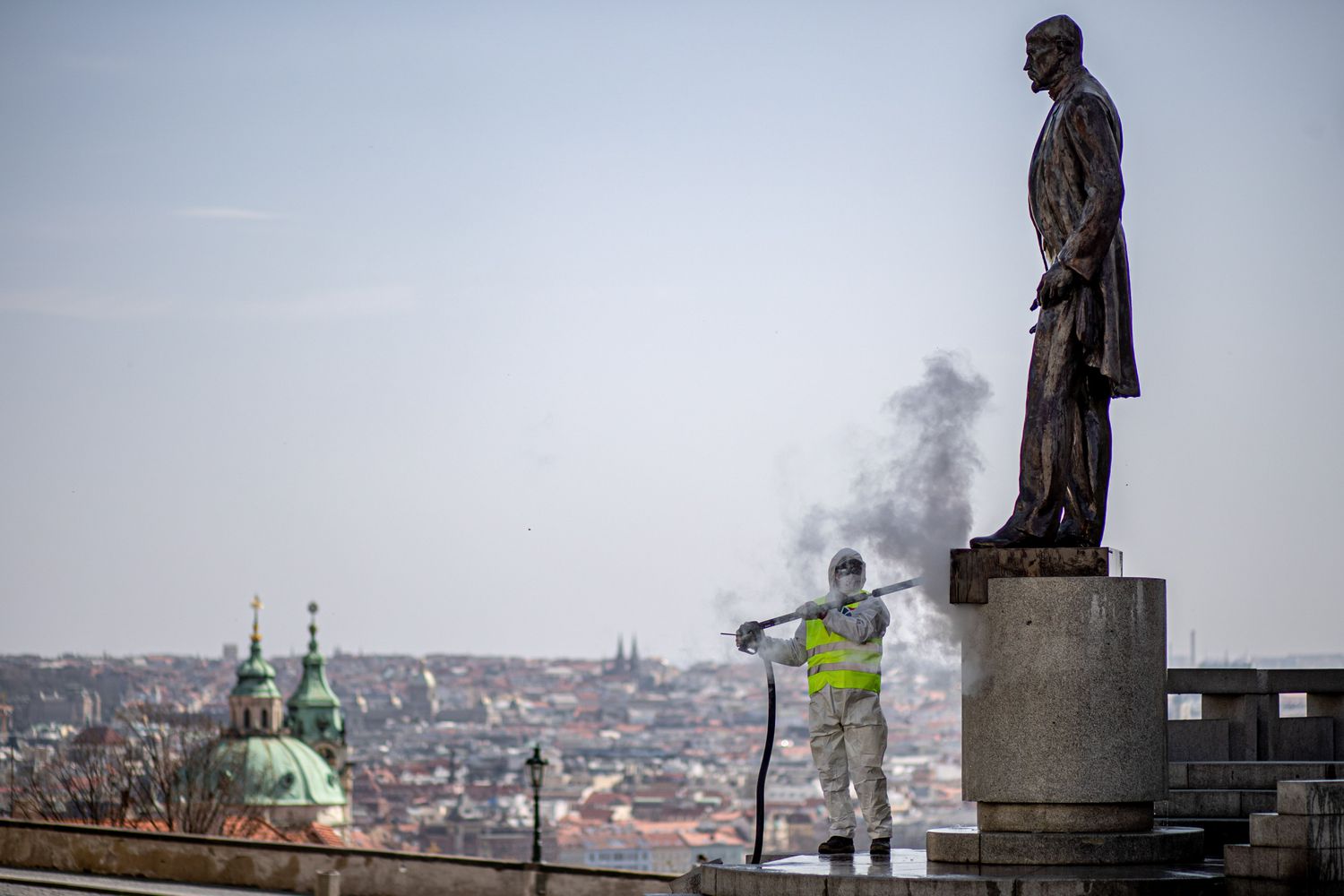 Uma pessoa da equipe de limpeza pública de Praga desinfeta a praça Hradcanske, na República Checa, nesta sexta-feira, para tentar conter o avanço do coronavírus.