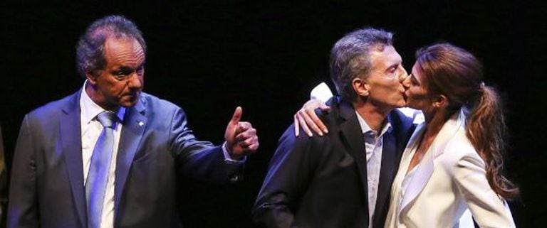 Macri recebe o beijo de sua esposa enquanto Scioli cumprimenta o público após o debate eleitoral de 18 de novembro.