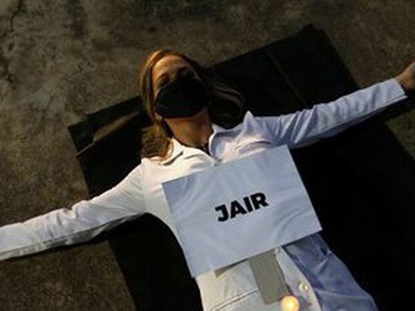 Enfermeira protesta com cartaz em que se lê "Jair", nome de um dos profissionais de saúde mortos pelo coronavírus no Brasil, na segunda.