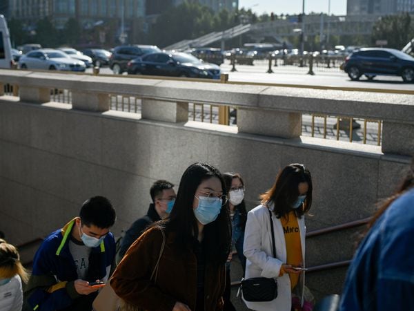 People wearing exit from an underpass in Beijing on October 19, 2020. (Photo by WANG Zhao / AFP)
