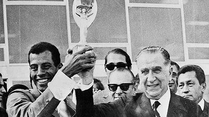 Carlos Alberto levanta a taça de campeão com o ditador Emílio Médici.