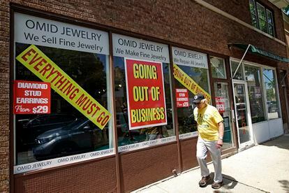 Homem passa na frente de uma loja que encerrou suas atividades, em Winnetka, em Illinois.