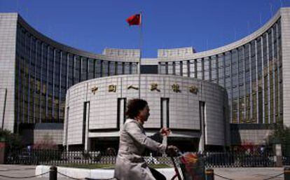 Mulher passa em frente à sede do Banco Popular da China, em Pequim.