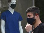 A pedestrian wearing a protective facemask, passes a mannequin wearing a similar mask in central Yerevan on June 2, 2020, amidst the COVID-19 outbreak, caused by the novel coronavirus. - Armenian Prime Minister Nikol Pashinyan, who turned 45 on June 1, said he and his family had tested positive for the new coronavirus and that he would be working from home. (Photo by Karen MINASYAN / AFP)
