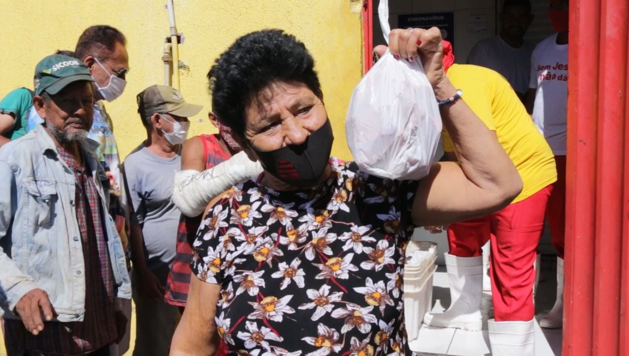 Mulher mostra nesta quarta-feira, 21 de julho, o saco plástico com ossos de boi doados pelo açougue Atacadão da Carne, em Cuiabá (MT).
