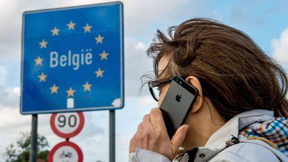 Uma mulher usa seu celular na fronteira franco-belga.