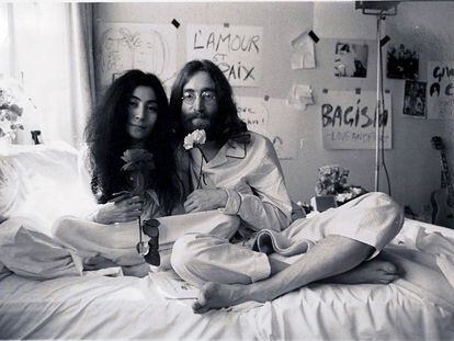 O cantor John Lennon posa de pijama na cama com sua mulher, Yoko Ono.