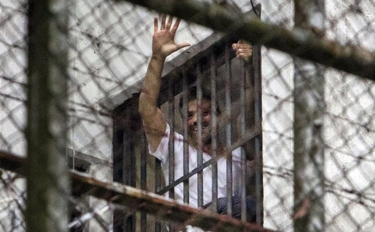 Leopoldo López acena de janela da prisão militar Ramo Verde, em Caracas.