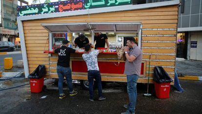 Três iraquianos em um restaurante de rua de Bagdá.