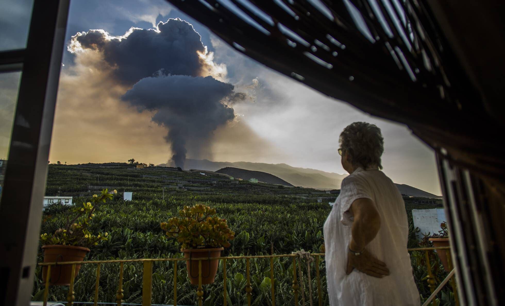 Uma mulher contempla a coluna de fumaça liberada pelo vulcão La Palma nesta quinta-feira.
