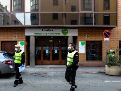 Dois agentes da Unidade Militar de Emergências (UME), protegidos com máscaras, na segunda-feira na entrada da casa de repouso para idosos DomusVi Albufera, na Espanha.