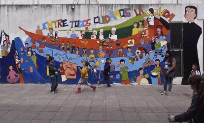 Um grupo de crianças brinca no pátio da escola da Virgem del Milagro, em cidade La Cárcova.