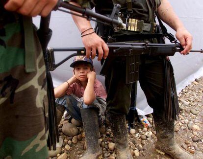 Um menino e os guerrilheiros das FARC em San Vicente de Calguán, no ano 2000.
