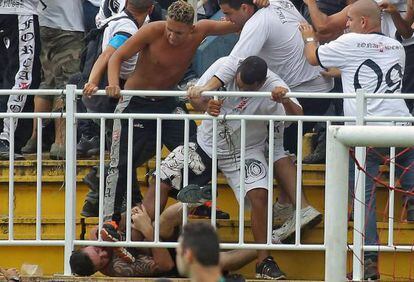 Torcedores em confronto na partida entre Vasco e Atl&eacute;tico Paranaense. AFP PHOTO/HEULER ANDREY