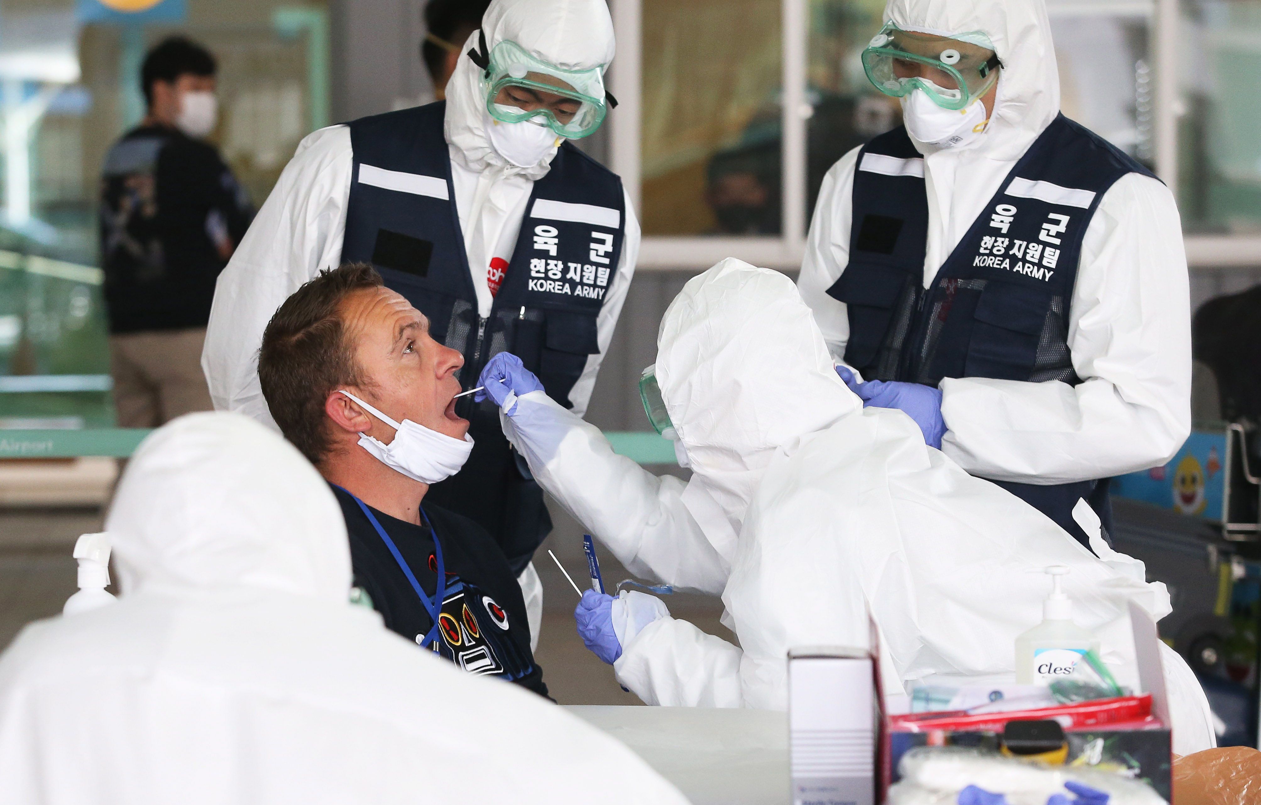 Agentes sanitários colhem amostras para exames de coronavírus no aeroporto de Incheon, na Coreia do Sul, na última sexta-feira. 