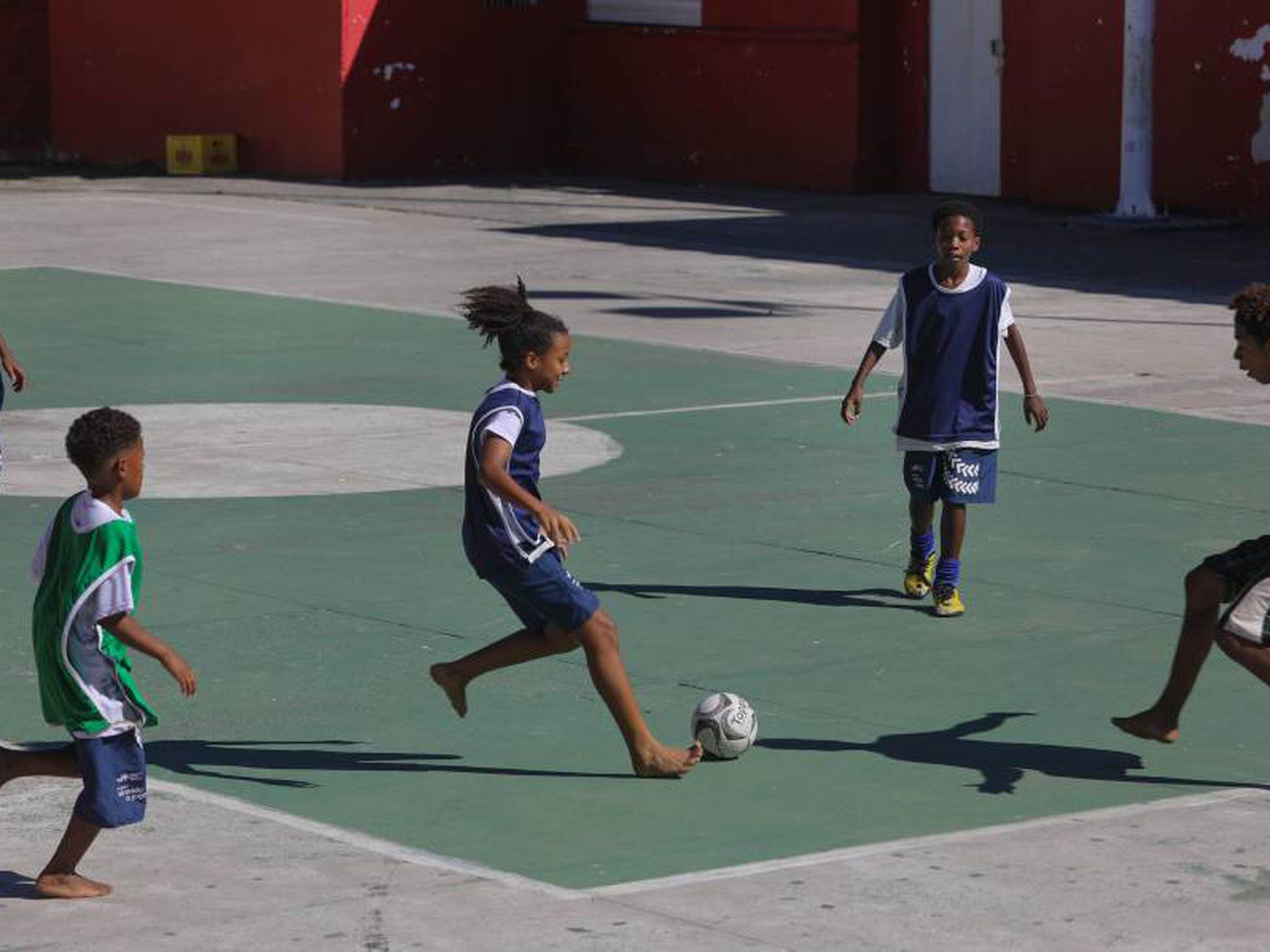 As crianças jogam futebol na escola