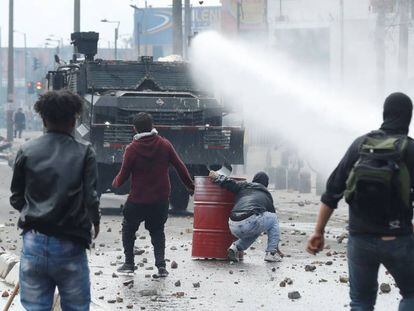 A polícia antidistúrbios em frente a um grupo de manifestantes nesta sexta-feira, em Bogotá.