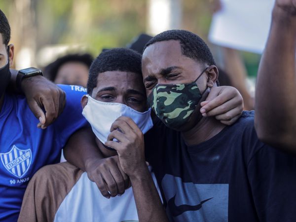 AME1012. SAO GONÇALO (BRASIL), 19/05/2020.- Dos jóvenes lloran durante el entierro de Joao Pedro Matos Pinto, que según parientes y amigos denuncian, fue asesinado ayer por la policía federal en la favela del Complejo de Salgueiro, en la ciudad de Sao Gonçalo, vecina de Río de Janeiro (Brasil). Organizaciones de la sociedad civil en Brasil, lideradas por Amnistía Internacional (AI), exigieron este martes explicaciones por irregularidades registradas durante operativos policiales realizados en favelas de Río de Janeiro, que han dejado 14 muertos en tan solo cuatros días. EFE/Antonio Lacerda