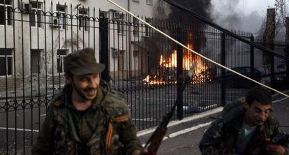 Separatistas pró-russos se afastam de carro em chamas, em Donestk.