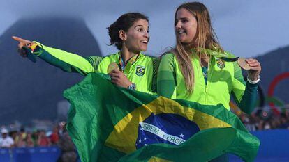 Martine e Kahena seguram a bandeira do Brasil no p&oacute;dio.