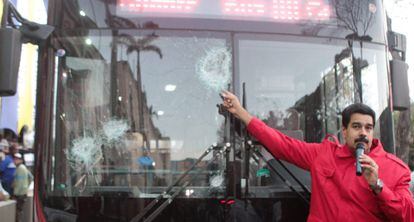 Maduro mostra ônibus danificado pelos protestos.