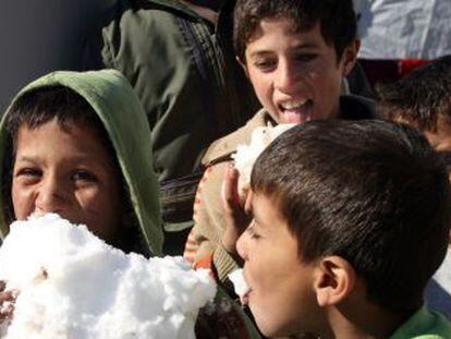 Crianças brincam com neve em um campo de refugiados no Líbano.